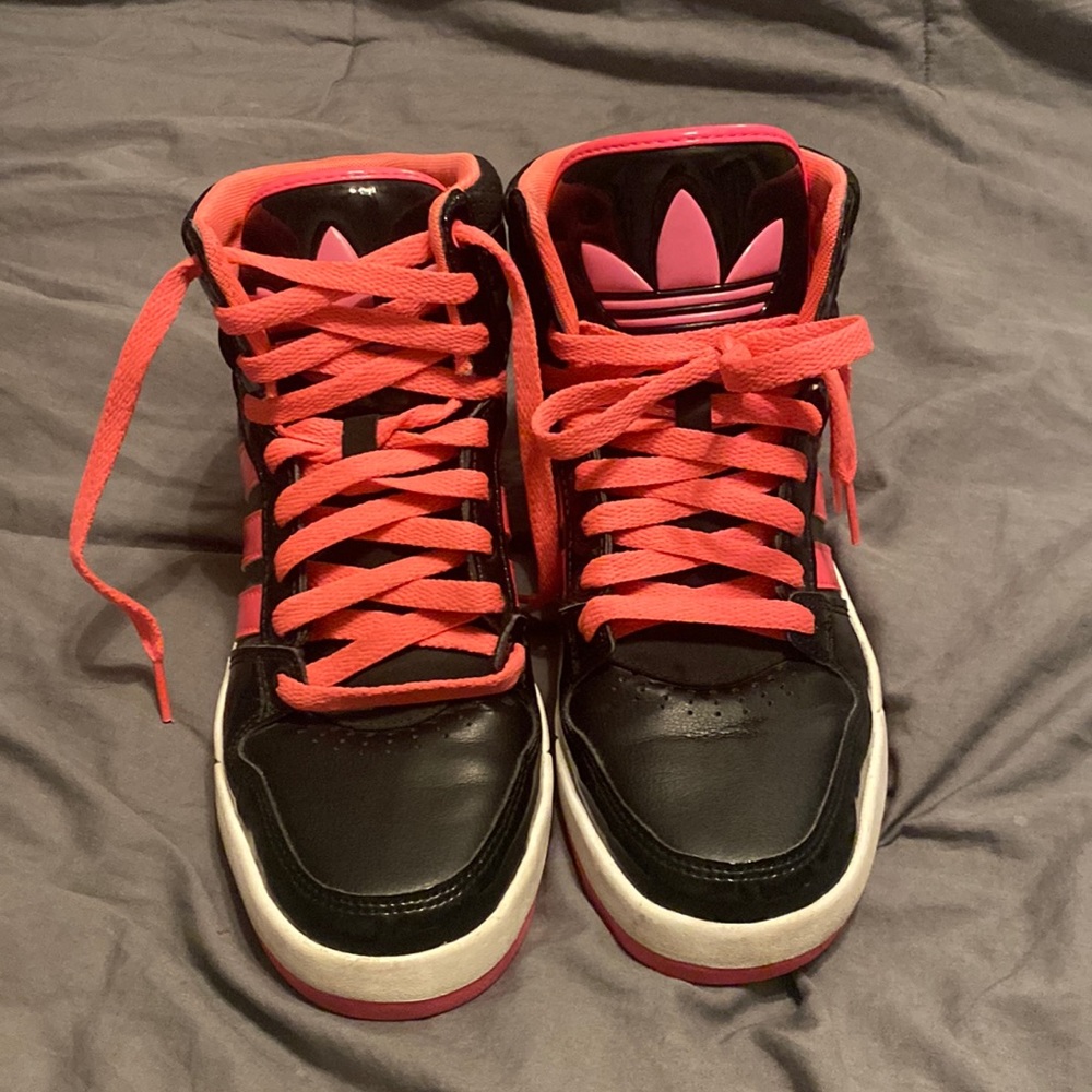 Black and pink high top adidas women’s shoe.